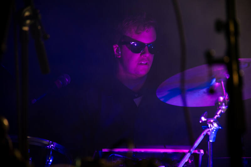 Preben behind the drums in sunglasses and pink light